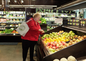 The Reality of Bariatric Surgery [image description: woman looking at fruit in produce section of grocery store]