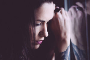DBT Skills for Eating Disorders [image description: woman look sad leaning against window]