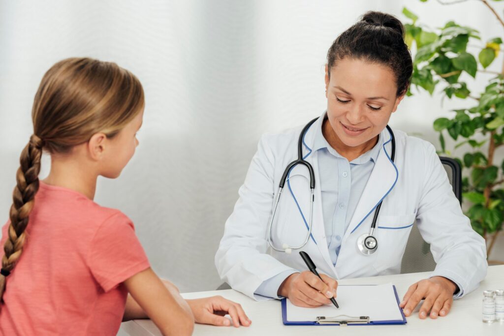 Early Intervention with Family-Based Treatment (FBT) for Eating Disorders [Image description: a teen girl sits next to a doctor who is writing notes; depicts a potential teen client with early signs of an eating disorder in California]