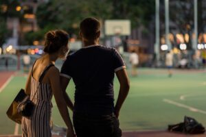 Dating with ARFID [Image description: a man and a woman viewed from the rear standing by a field] Represents a potential person with ARFID on a date